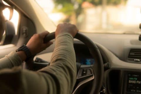 Motorista de aplicativo dirigindo veículo, ilustrando debate sobre o futuro da profissão após projeção do CEO da Uber