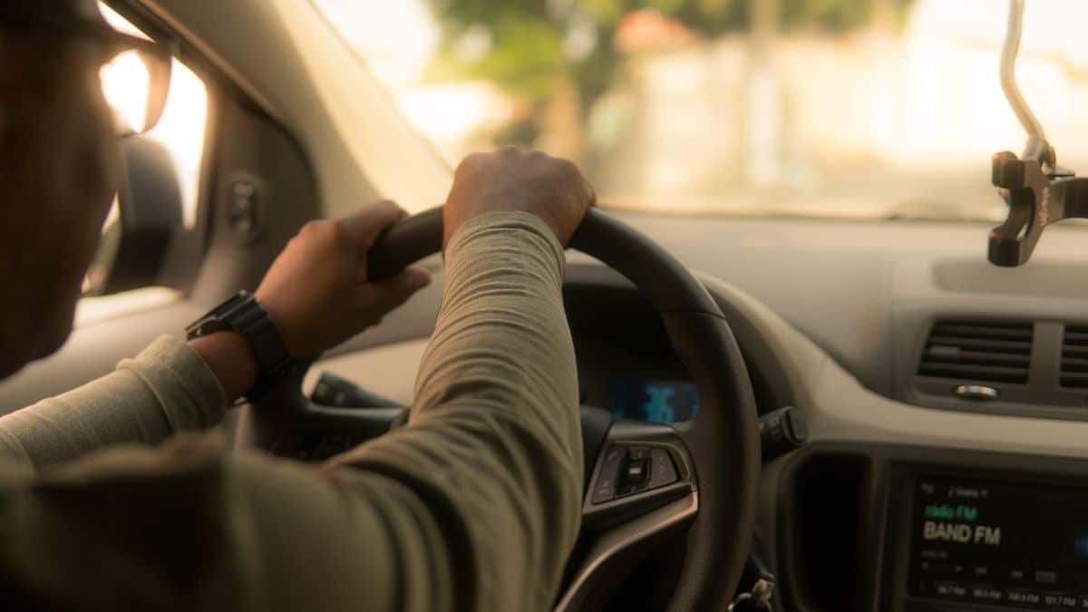 Motorista de aplicativo dirigindo veículo, ilustrando debate sobre o futuro da profissão após projeção do CEO da Uber