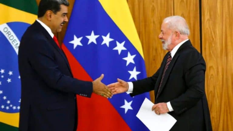 Presidente Lula cumprimenta Nicolás Maduro durante encontro oficial, com bandeiras do Brasil e da Venezuela ao fundo