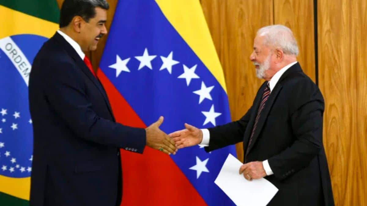 Presidente Lula cumprimenta Nicolás Maduro durante encontro oficial, com bandeiras do Brasil e da Venezuela ao fundo